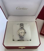 This Cartier watch features a bright silver case, a sleek round dial, a classic